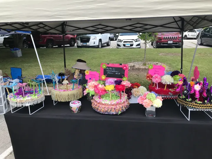 A table of baskets and crafts under a tent.
