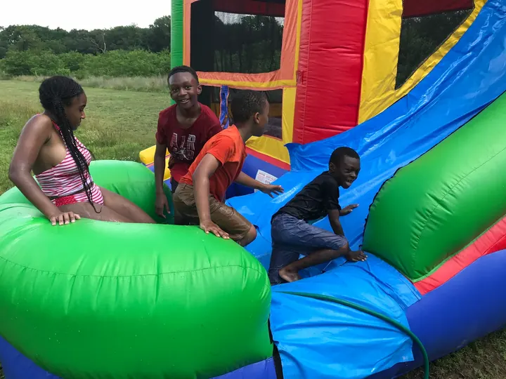 Kids playing on an inflatable slide.