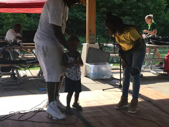 A man dancing with a little girl under the shelter.