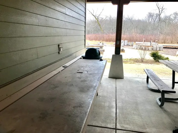 Inside a covered picnic shelter with tables.