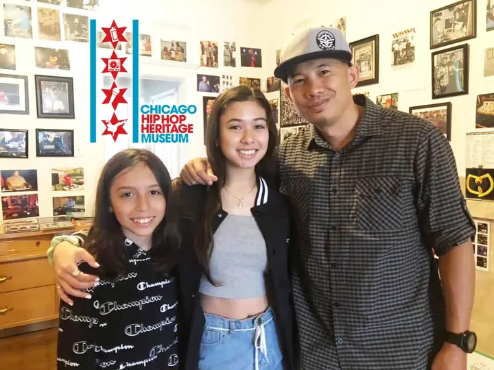 A man posing with two young women in the museum.