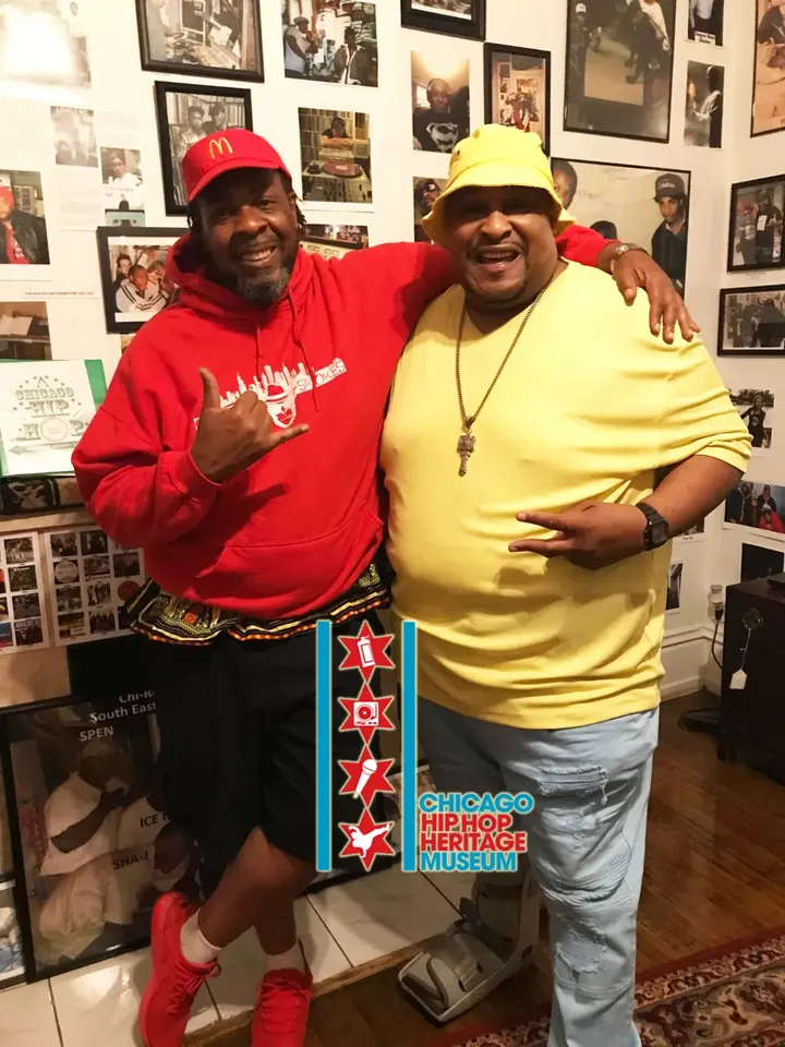 Two men in red and yellow posing at the museum.