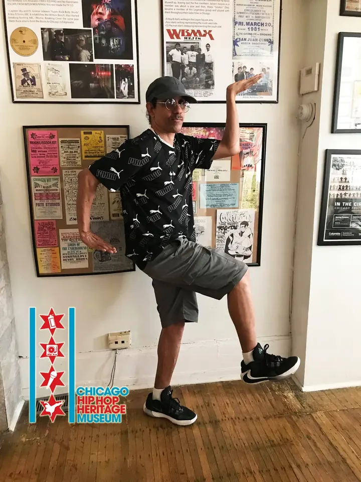 A visitor kicking one leg up in front of framed photos.